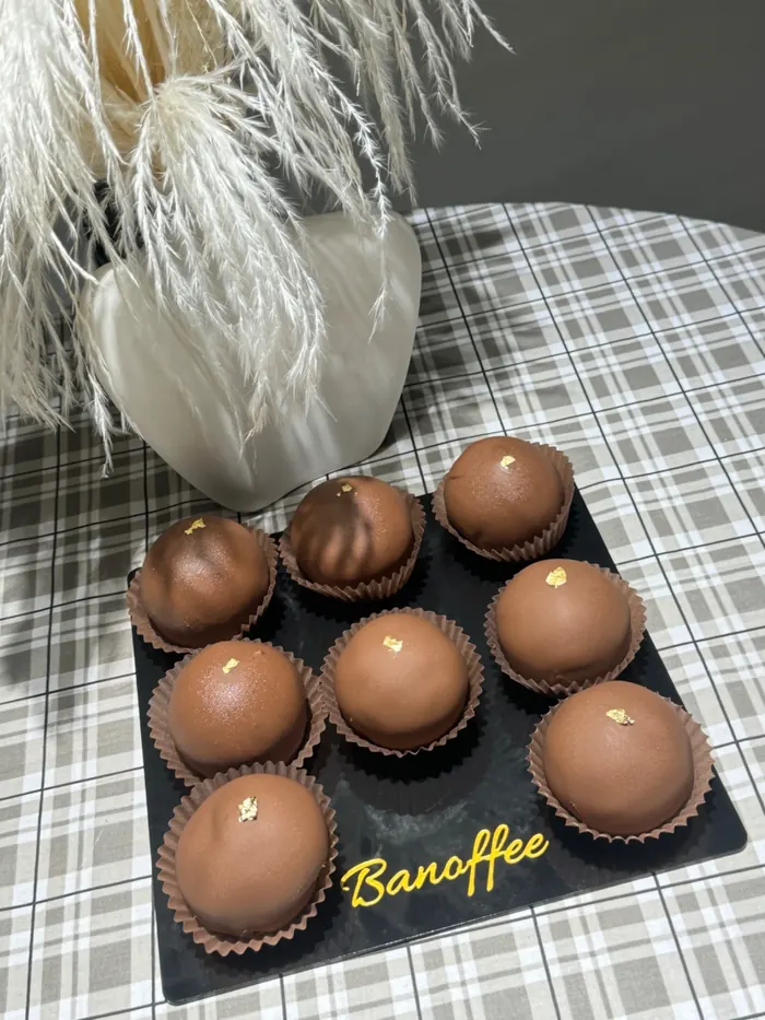 Шоколадные моти на чёрной доске с логотипом Banoffee